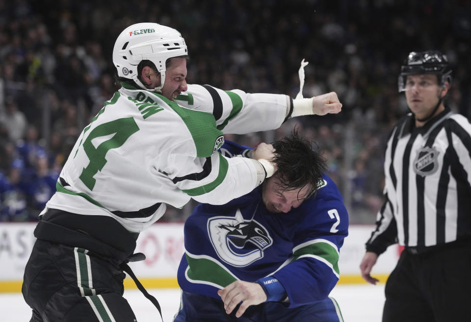 Dallas Stars' Jamie Benn, left, and Vancouver Canucks' Luke Schenn fight during the second period of an NHL hockey game in Vancouver, British Columbia, Monday, April 18, 2022. (Darryl Dyck/The Canadian Press via AP)