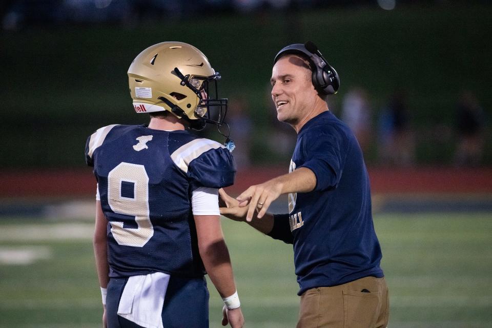 Shrewsbury head coach John Aloisi talks to quarterback Andrew Vincequere during last week's game against Acton-Boxborough.