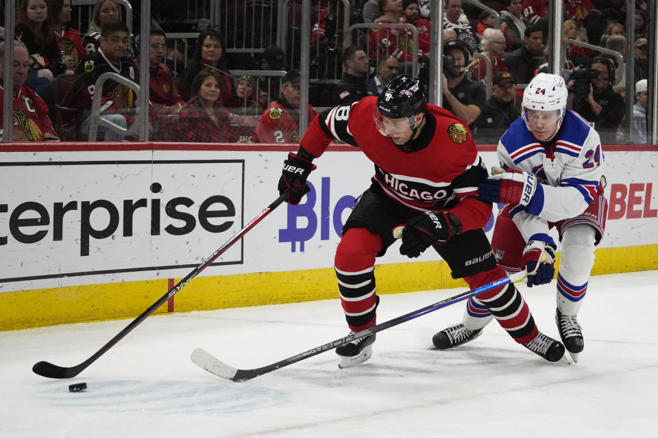 New York Rangers right wing Kaapo Kakko (24) defends against Chicago Blackhawks defenseman Jack Johnson (8) during the second period of an NHL hockey game Sunday, Dec. 18, 2022, in Chicago. (AP Photo/David Banks)