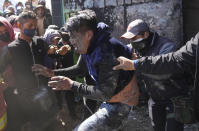 Cultivadores de coca antigubernamentales golpean a otro cocalero que dicen que es partidario del gobierno, después de incendiar el mercado paralelo de hoja de coca, en La Paz, Bolivia, el jueves 8 de septiembre de 2022. (AP Foto/Juan Karita)