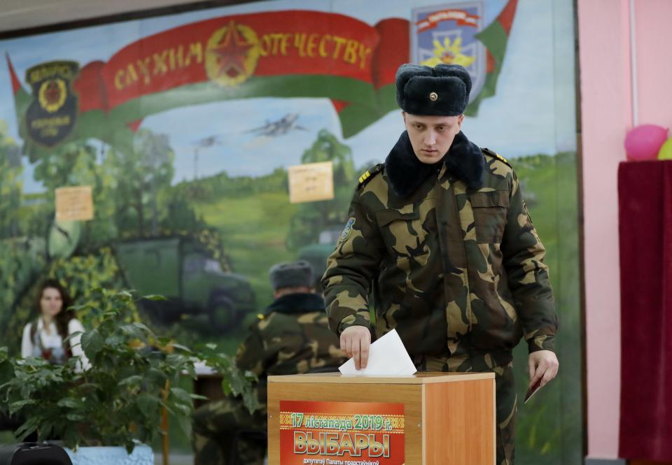 In this photo taken on Thursday, Nov. 14, 2019, a Belarus' Army serviceman casts his ballot during an early election at a polling station in Minsk, Belarus, ahead of the parliamentary election to be held on Sunday. (AP Photo/Sergei Grits)