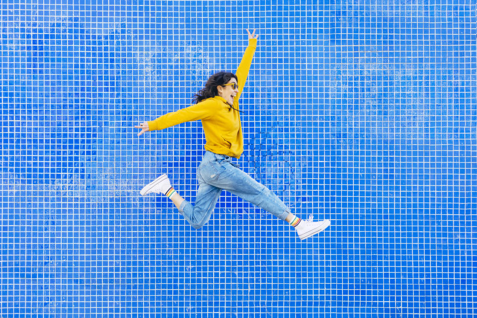 Woman jumping in front of a blue background