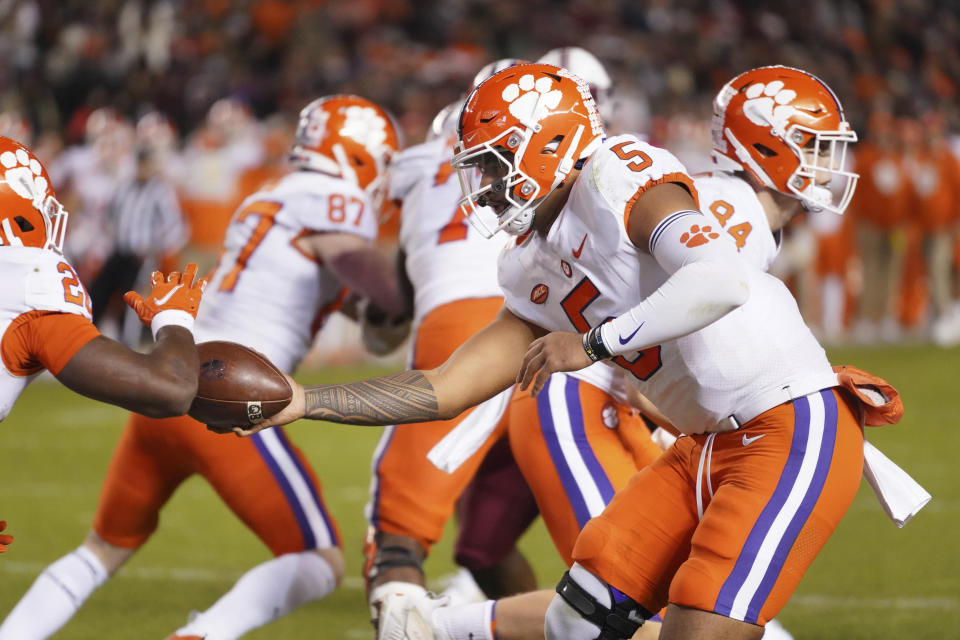 Clemson quarterback D.J. Uiagalelei (5) hands the ball off to running back Kobe Pace (20) during the second half of an NCAA college football game Saturday, Nov. 27, 2021, in Columbia, S.C. Clemson won 30-0. (AP Photo/Sean Rayford)