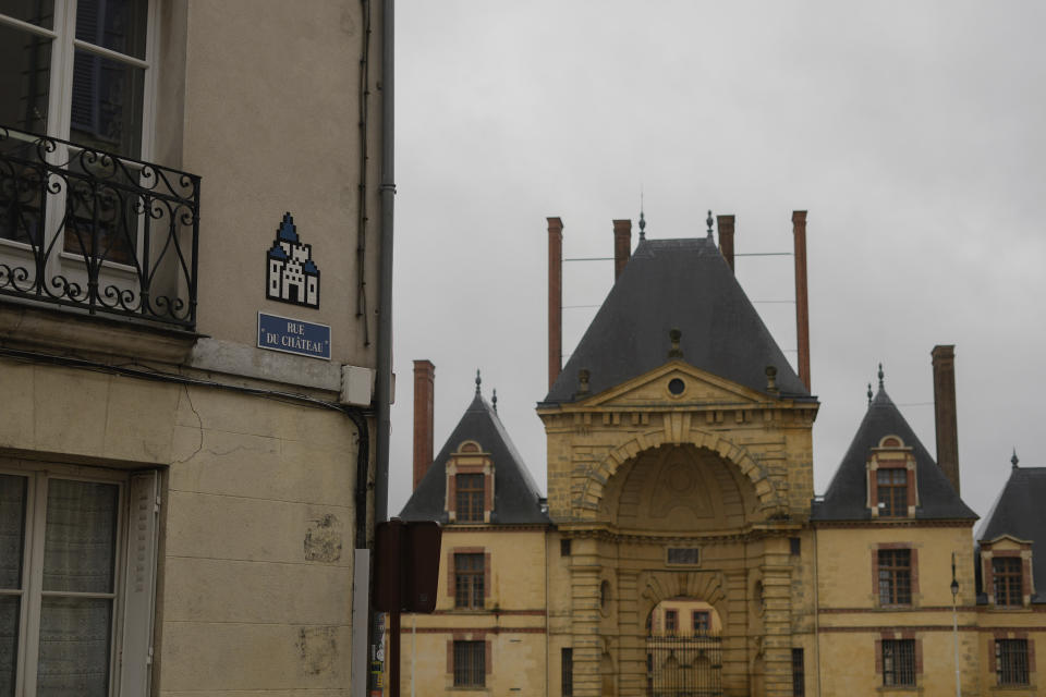 A mosaic by French artist Invader, top left, is seen on a street of Fontainebleau, south of Paris, Thursday, Feb. 29, 2024. For the Paris Olympics, it could almost have been a new sport: Score points by scouring France's capital for mosaics that a mystery artist who calls himself "Invader" has cemented to walls across the city, across the world and even had carried aloft to the International Space Station. (AP Photo/Thibault Camus)