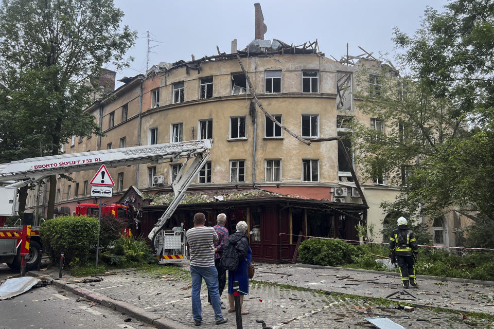 People stand outside a damaged building after a Russian missile attack in Lviv, Ukraine, Thursday, July 6, 2023. (AP Photo/Mstyslav Chernov)