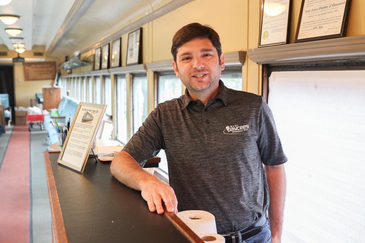 Kent Jaycee member Andrew Madonio stands behind the bar in the Marvin Kent train car that serves as the Jaycee’s meeting place on Franklin Avenue in downtown Kent.