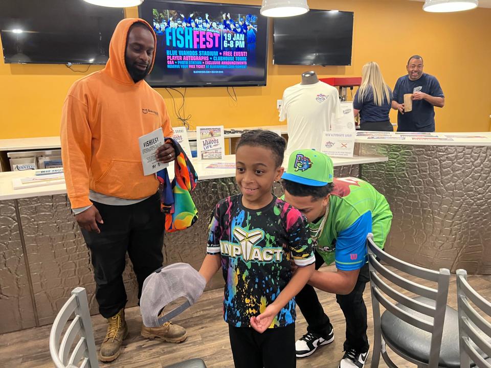 Pensacola Catholic grad Jordan McCants signs an autograph for a young fan at the Blue Wahoos' Fish Fest event on Jan. 10, 2023 inside season-ticket holder lounge at Blue Wahoos Stadium.