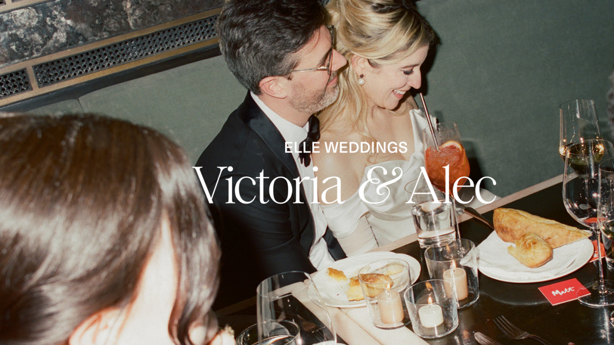 a man and woman kissing at a table with food and drinks