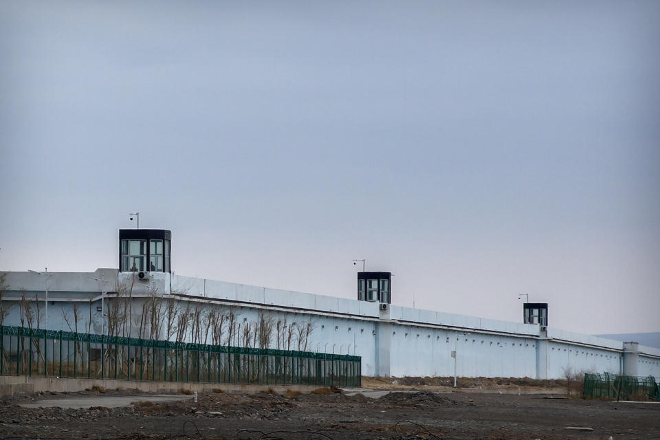 FILE - People stand in a guard tower on the perimeter wall of the Urumqi No. 3 Detention Center in Dabancheng in western China's Xinjiang Uyghur Autonomous Region on April 23, 2021. After a U.N. report concluding that China's crackdown in the far west Xinjiang region may constitute crimes against humanity, China used a well-worn tactic to deflect criticism: blame a Western conspiracy. (AP Photo/Mark Schiefelbein, File)