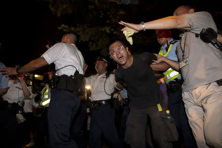 A pro-democracy activist is detained by the police during a confrontation outside the hotel where China's National People's Congress Standing Committee Deputy General Secretary Li Fei is staying, in Hong Kong September 1, 2014. REUTERS/Tyrone Siu