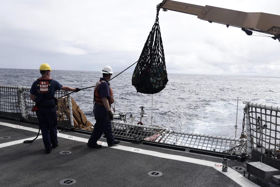 In this Nov. 4, 2019 photo provided by the U.S. Coast Guard, Coast Guard Cutter Bertholf crew members use a crane and cargo net to transfer bales of contraband from Bertholf's 35-foot Long Range Interceptor boat to the cutter following an at-sea interdiction of a low-profile go-fast vessel during Bertholf's patrol to the Eastern Pacific Ocean. An estimated $312 million worth of cocaine seized from smugglers in the eastern Pacific Ocean has been brought to San Diego. About 18,000 pounds (8,165 kilograms) of the drug was offloaded Wednesday, Dec. 18, 2019, from the Coast Guard cutter Bertholf. (Petty Officer 2nd Class Paul Krug/U.S. Coast Guard via AP)