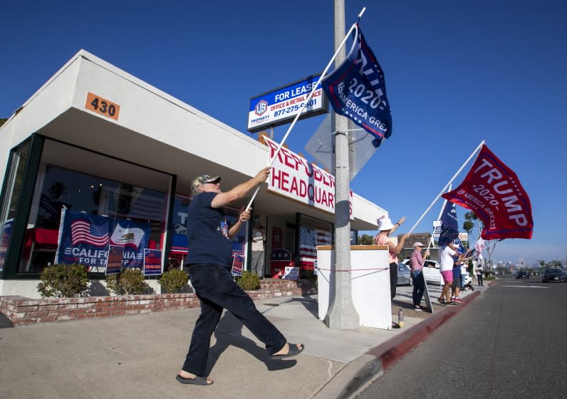 NEWPORT BEACH, CA - NOVEMBER 03: Pres. Trump supporter Steve Martin, left, of Westminster, joins fellow supporters as he dances and cheers on passing motorists in front of the Republican Party headquarters on election day Tuesday, Nov. 3, 2020 in Newport Beach. (Allen J. Schaben / Los Angeles Times)