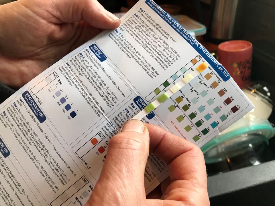 In a test of her home's tap water, Kari Rasmussen, of Grosse Pointe Park, checks a test strip for excess chlorine and other contaminants and finds none on May 4, 2023, persuading her to stop buying bottled water.