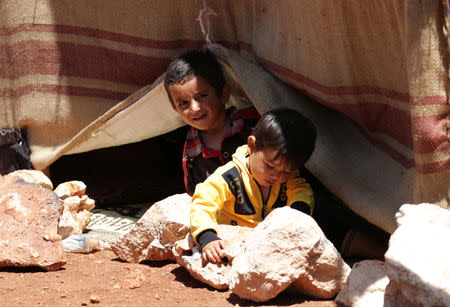 FILE PHOTO: A displaced Syrian boy looks at the camera, in an olive grove at the town of Atmeh, Idlib province, Syria May 19, 2019. REUTERS/Khalil Ashawi