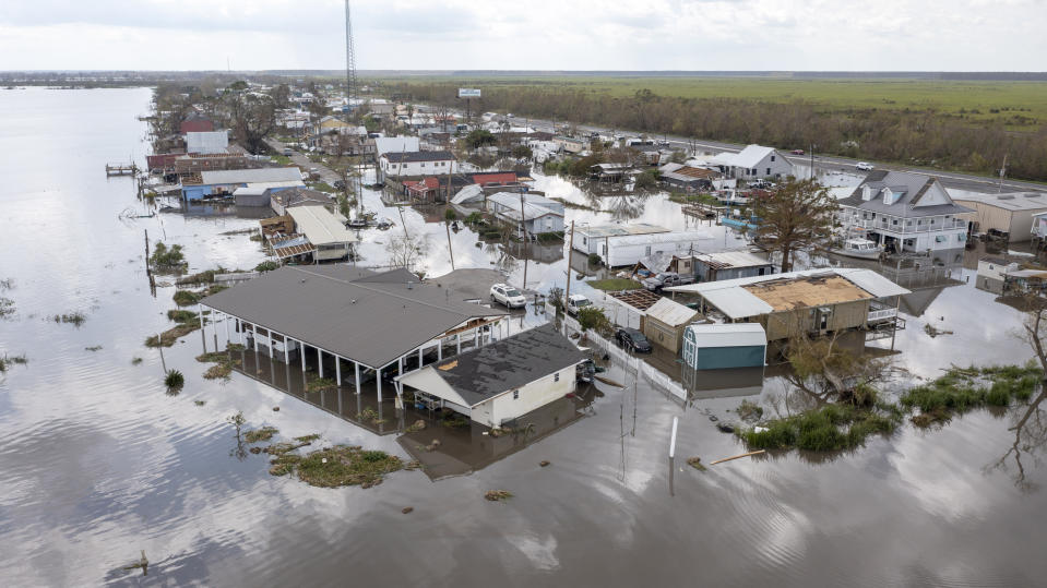 FILE - In this aerial photo taken with a drone, flood waters surround storm damaged homes on Aug. 31, 2021, in Lafourche Parish, La., as residents try to recover from the effects of Hurricane Ida. Ten Filipino men who worked for a major offshore oil industry employer claim in a federal lawsuit in Feburary 2022 that they were treated like prisoners at a company bunkhouse — and that two of them were abandoned there when Hurricane Ida struck the Louisiana Gulf Coast in 2021. (AP Photo/Steve Helber, File)