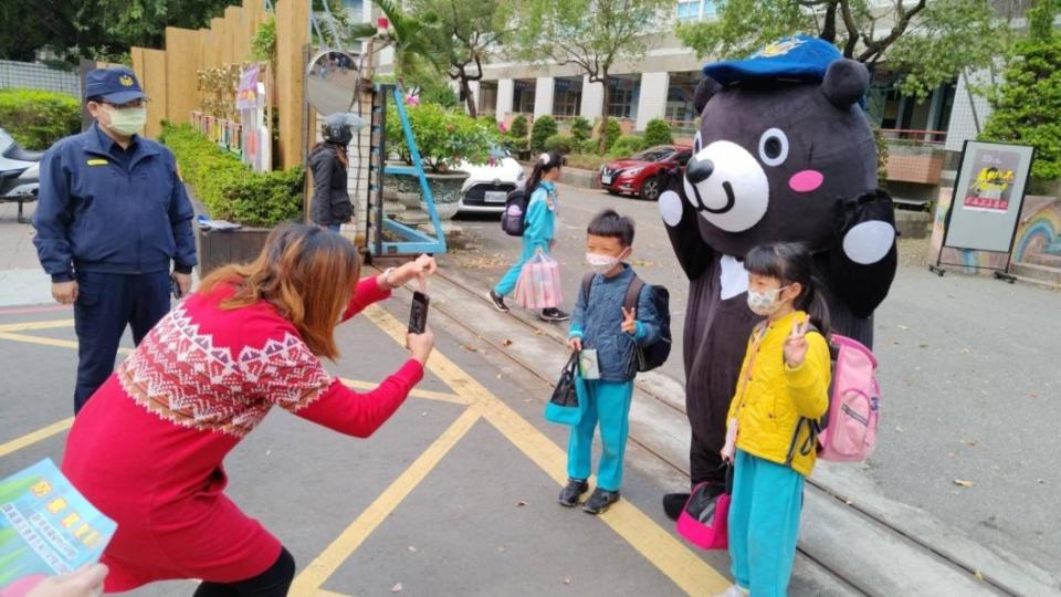 學童們看見黑熊娃娃超興奮，開心地與娃娃合影留念。（圖／TVBS）