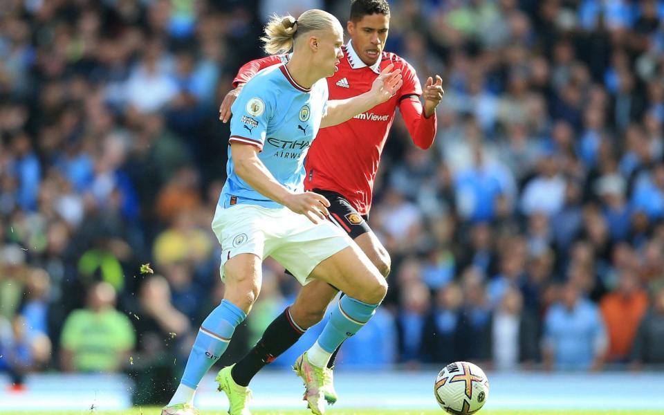 Manchester City's Norwegian striker Erling Haaland (L) vies with Manchester United's French defender Raphael Varane (R)  - AFP / Getty