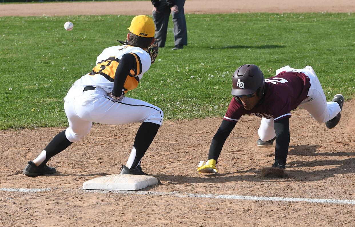 Tre Walker, shown here diving back to first base, and his Aquinas teammates again plan to play aggressive on the basepaths.