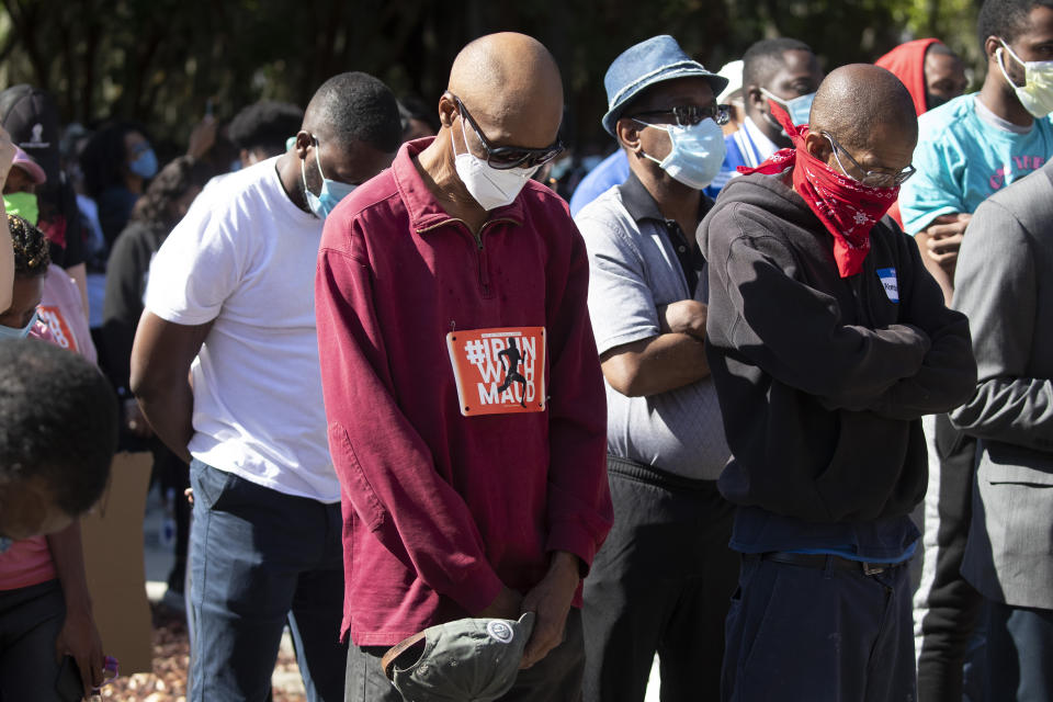 People pray during a rally to protest the shooting of Ahmaud Arbery, an unarmed black man Friday, May 8, 2020, in Brunswick Ga. Two men have been charged with murder in the February shooting death of Arbery, whom they had pursued in a truck after spotting him running in their neighborhood. (AP Photo/John Bazemore)pursued in a truck after spotting him running in their neighborhood. (AP Photo/John Bazemore)