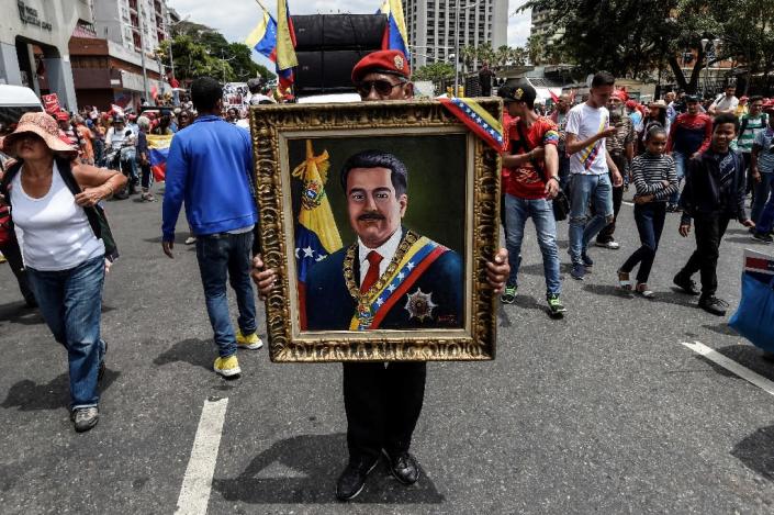 A painting depicting Venezuelan President Nicolas Maduro is displayed by a supporter during a pro-government demonstration in Caracas (AFP Photo/Juan BARRETO)