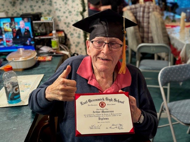 Arthur Masterson holding his high school diploma on Dec. 25, 2023.