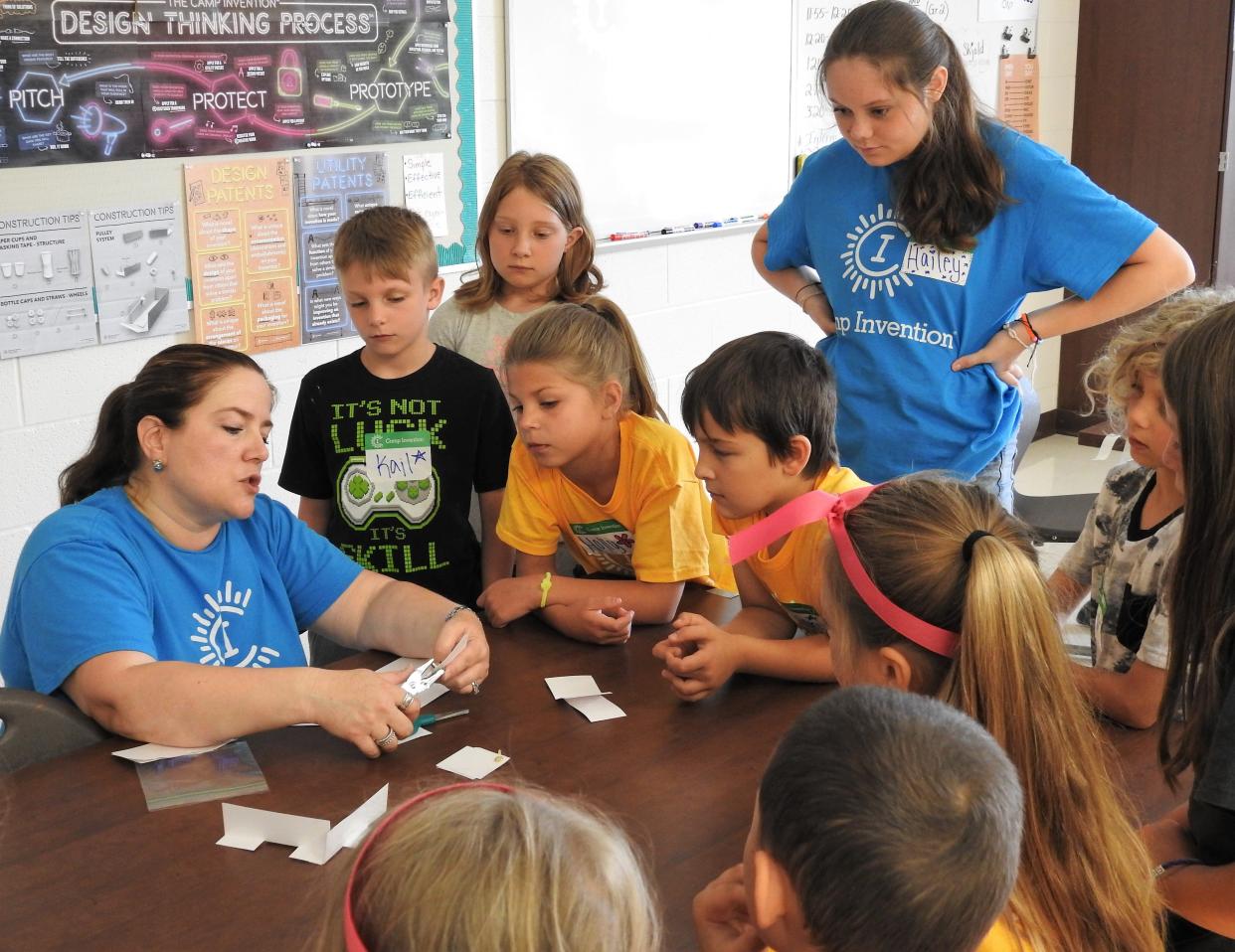 Laura Skjold does an activity demonstration for second-grade students during Camp Invention at Coshocton Elementary School. High school students, many who went through Camp Invention when they were younger, serve as assistants.
