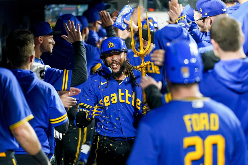 Seattle Mariners' J.P. Crawford holds a trident in the dugout after his grand slam against the Texas Rangers during the fourth inning of a baseball game Friday, Sept. 29, 2023, in Seattle. (AP Photo/Lindsey Wasson)