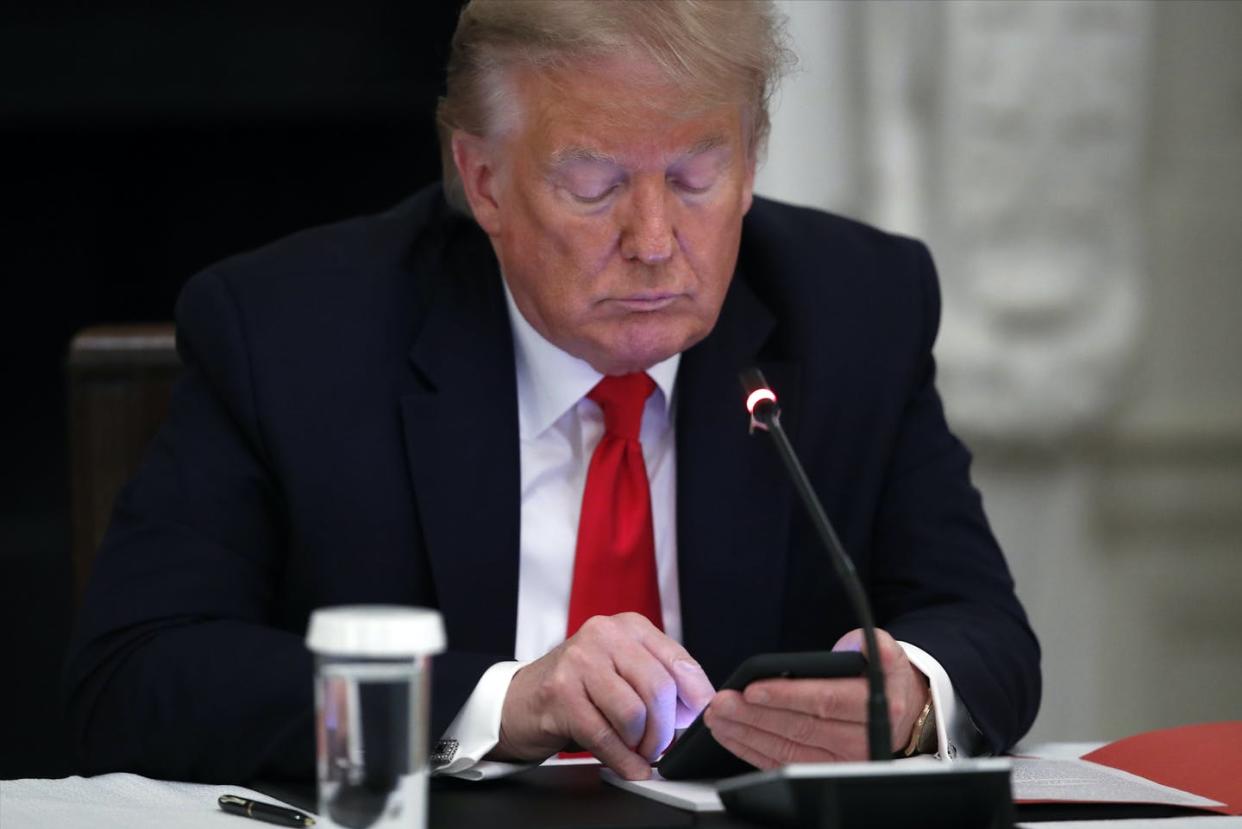 <span class="caption">President Donald Trump works on a smartphone, a common tool in his political communication efforts.</span> <span class="attribution"><a class="link " href="http://www.apimages.com/metadata/Index/Virus-Outbreak-Trump/c0350128f27e4168864d2ccb0e6b3cd7/17/0" rel="nofollow noopener" target="_blank" data-ylk="slk:AP Photo/Alex Brandon;elm:context_link;itc:0;sec:content-canvas">AP Photo/Alex Brandon</a></span>