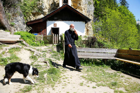 Hermit Stan Vanuytrecht of Belgium walks with his dog outside the hermitage in Saalfelden, Austria, May 22, 2017. Picture taken May 22, 2017. REUTERS/Leonhard Foeger