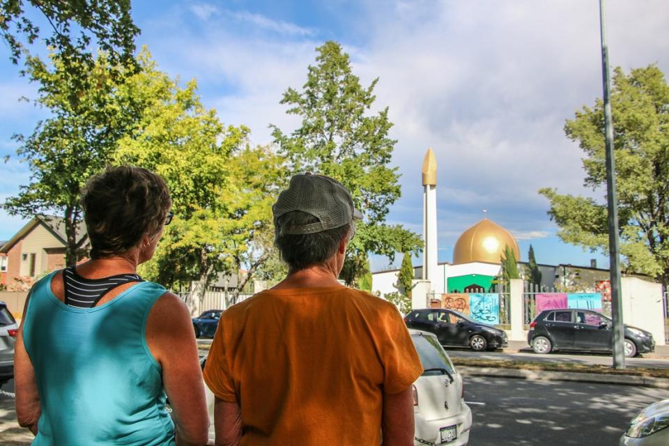 Two tourists in Christchurch stand opposite the Al Noor Mosque, the site of the 2019 attacks that killed 51 worshippers. (Photo by Adam Bradley/SOPA Images/LightRocket via Getty Images)