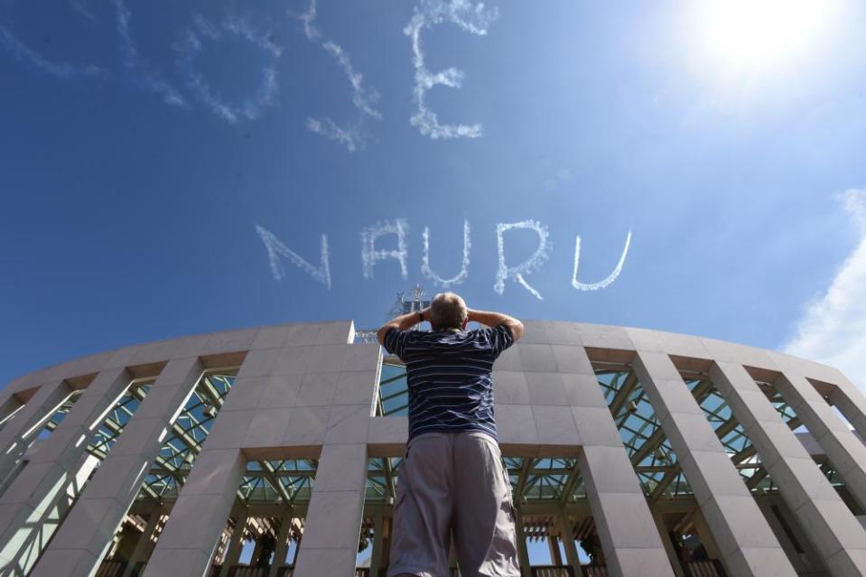 A plane skywrites ‘Close Nauru” above Parliament House