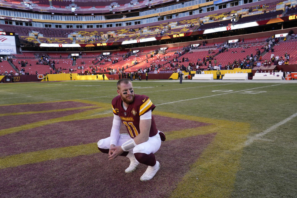 Washington Commanders quarterback Carson Wentz kneels on the field after a 24-10 loss to the Cleveland Browns, Sunday, Jan. 1, 2023, in Landover, Md. (AP Photo/Susan Walsh)