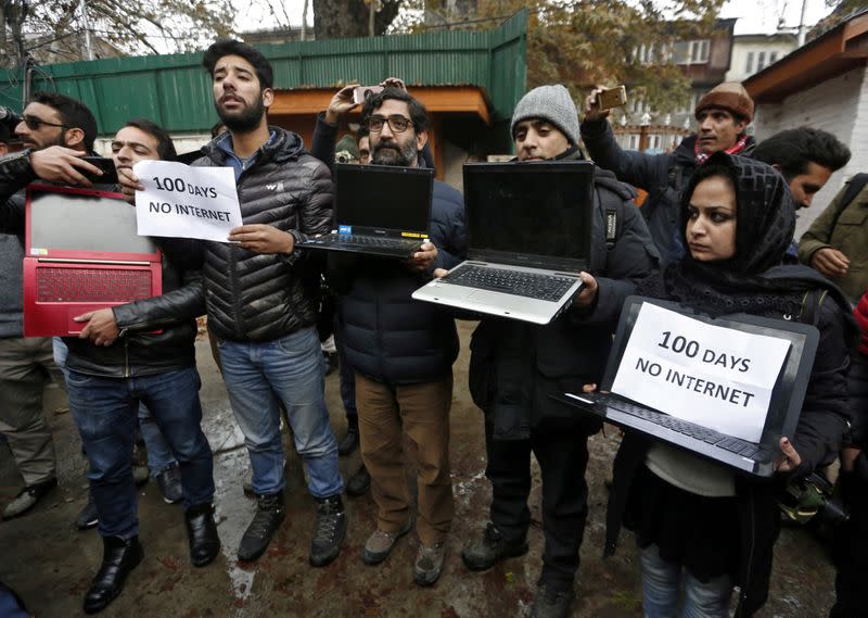 FILE PHOTO: Kashmiri journalists display laptops and placards during a protest demanding restoration of internet service, in Srinagar