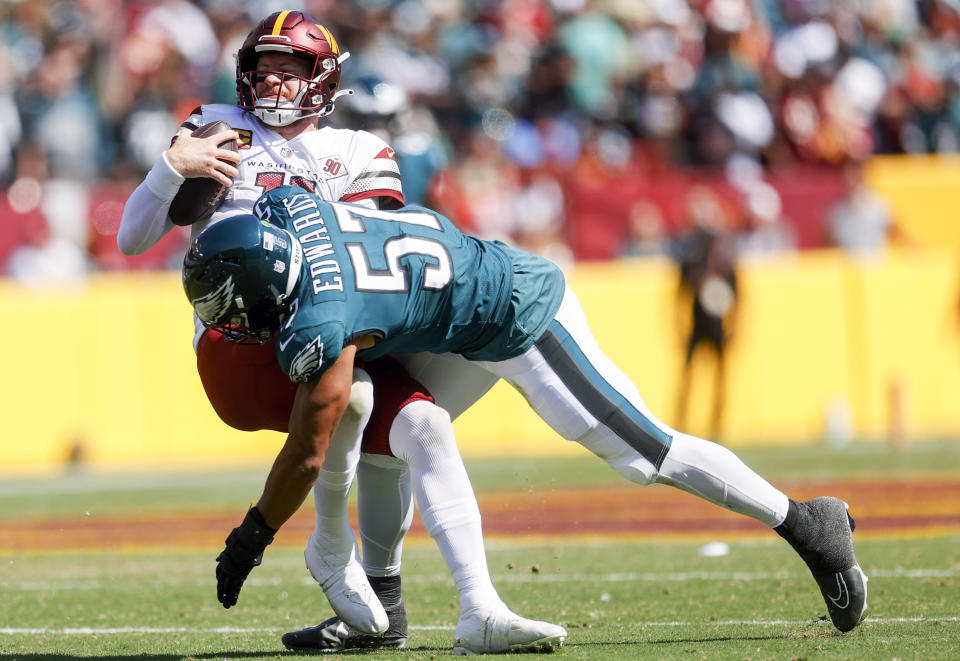 Philadelphia Eagles linebacker T.J. Edwards (57) hits Washington Commanders quarterback Carson Wentz (11) during the first half of an NFL football game, Sunday, Sept. 25, 2022 in Landover, Md. (Shaban Athuman/Richmond Times-Dispatch via AP)