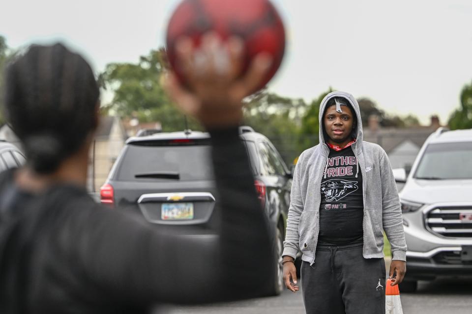 Linden-McKinley seniors Nae Featherstone, 17, and Dave Smith, 17, play a game of curb ball at the tailgate before the homecoming football game against Centennial High School on Sept. 23.