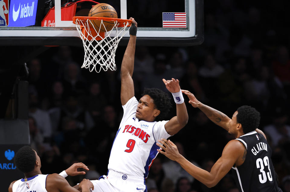 Detroit Pistons forward Ausar Thompson (9) scores against Brooklyn Nets center Nic Claxton (33) during the first half of an NBA basketball game, Saturday, Dec. 23, 2023, in New York. (AP Photo/Noah K. Murray)