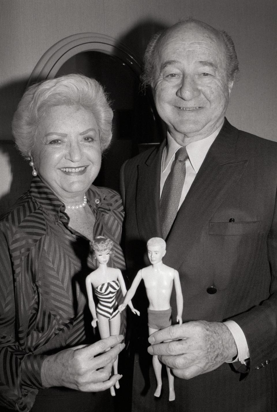 A portrait of Ruth and Elliott Handler, the couple who introduced the Barbie doll in 1959, holding a Barbie and Ken doll.