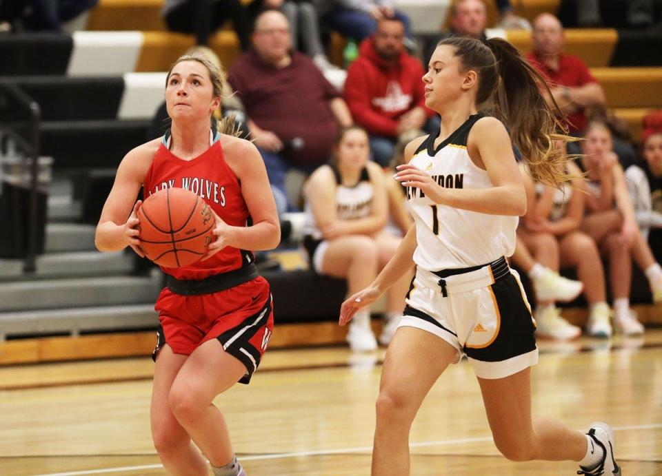 Winfield Mt. Union senior Keetyn Townsley goes in for a layup chased by New London’s Natalie Burden in the Wolves 54-24 win Friday night at New London.