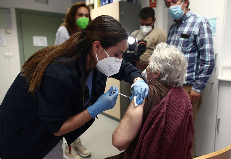 Una sanitaria inyecta la primera dosis de la vacuna de Pfizer contra el coronavirus a una anciana en el Centro de salud Rejas en Madrid 