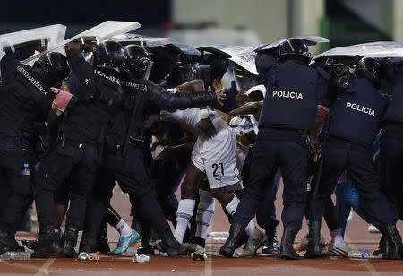 Riot police shield Ghana's John Boye (21) and team mates from objects thrown by Equatorial Guinea fans at the end of the first half of the 2015 African Cup of Nations semi-final soccer match in Malabo February 5, 2015. REUTERS/Amr Abdallah Dalsh