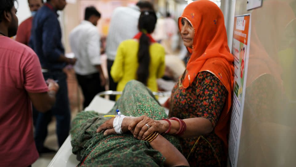 A woman stands beside her family member who is suffering from heatstroke in Varanasi, India, on May 30, 2024. - Indranil Aditya/NurPhoto/Getty Images