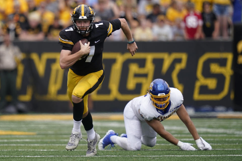 Iowa quarterback Spencer Petras (7) runs from South Dakota State defensive end Reece Winkelman, right, during the second half of an NCAA college football game, Saturday, Sept. 3, 2022, in Iowa City, Iowa. Iowa won 7-3. (AP Photo/Charlie Neibergall)