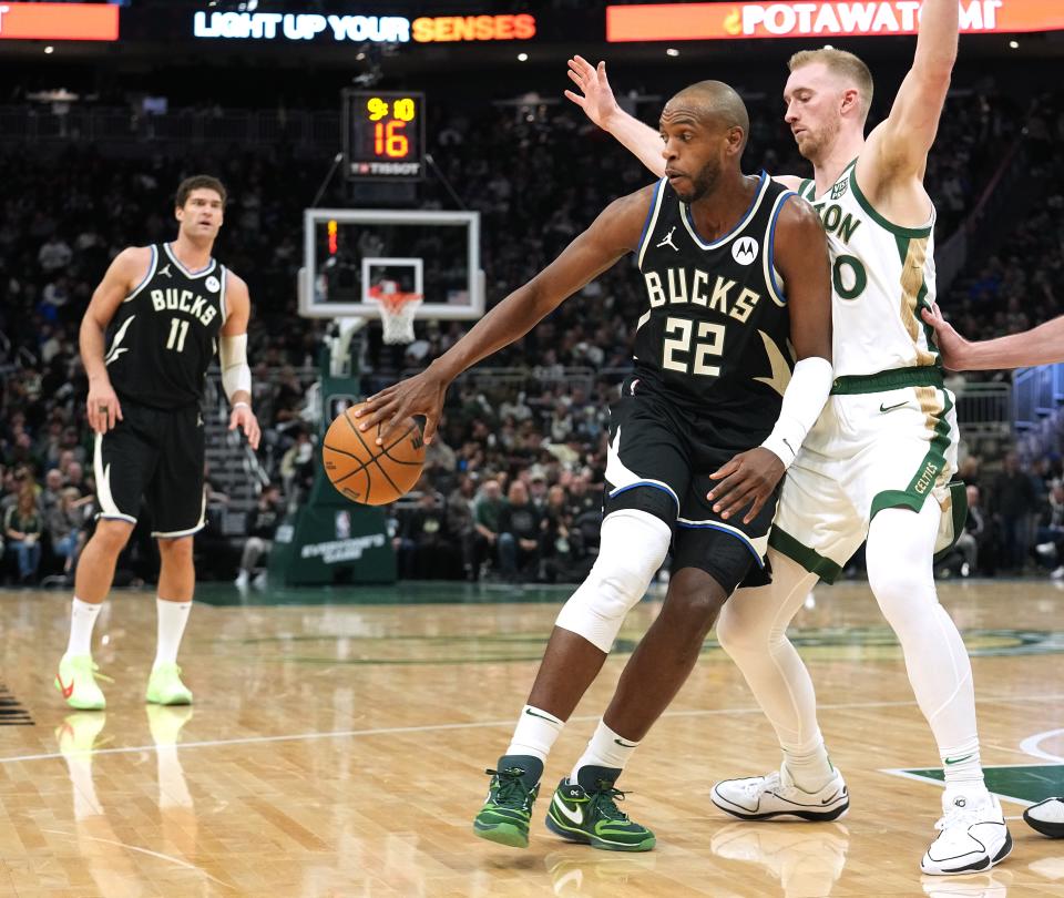 Milwaukee Bucks forward Khris Middleton (22) passes the ball to center Brook Lopez (11) while being guard by Boston Celtics forward Sam Hauser (30) during the second half of their game against the Boston Celtics Thursday. He won't play Sunday against the Sacramento Kings.
