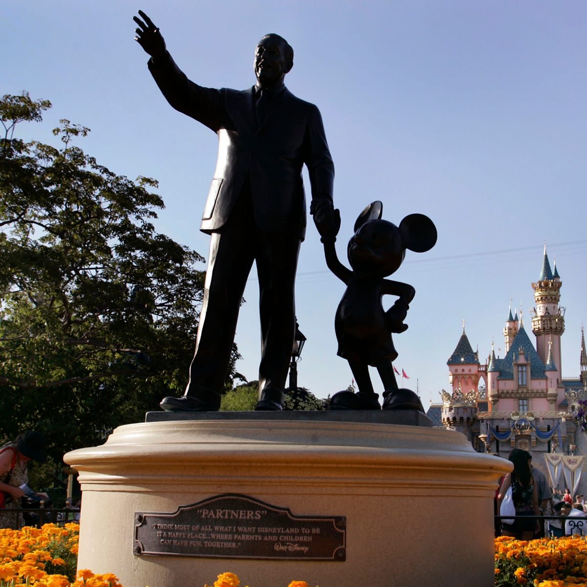 Sleeping Beauty's Castle can be seen in the backround as people make their way past the "Partners" statue (depicting Walt Disney and Mickey Mouse) at Disneyland, Friday July 15, 2005, in Anaheim. Disneyland celebrated its 50th anniversary on July 17, 2005. (Photo by Richard Hartog/Los Angeles Times via Getty Images)