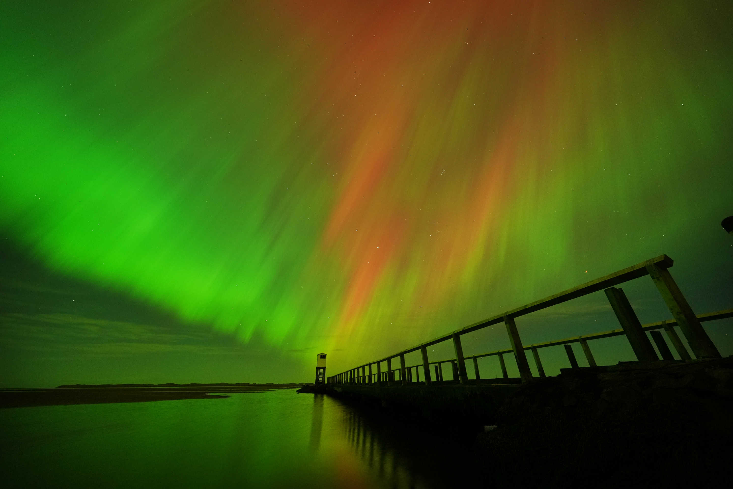 The Northern Lights, also known as the Aurora Borealis, seen in an incredible display in the skies over the refuge hut on the causeway leading to Holy Island in Northumberland, on the North East coast of England, in the early hours or Friday morning on October 11, 2024. (Owen Humphreys/PA Images via Getty Images)