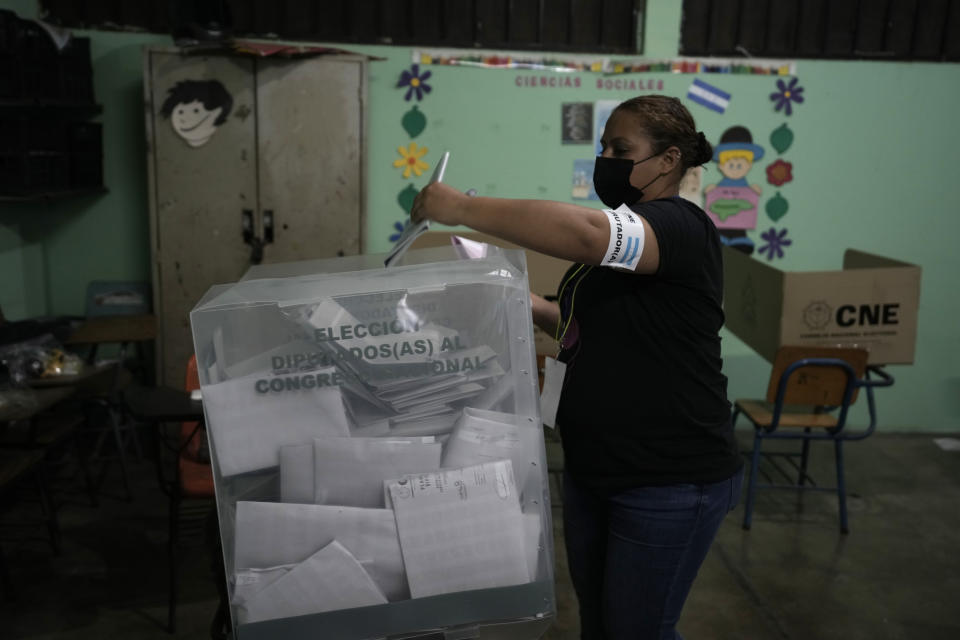 An election worker casts her ballot during general elections in Tegucigalpa, Honduras, Sunday, Nov. 28, 2021. The National Electoral Council called on political parties to refrain from declaring their candidates victorious or providing partial vote totals while voting was ongoing. (AP Photo/Moises Castillo)