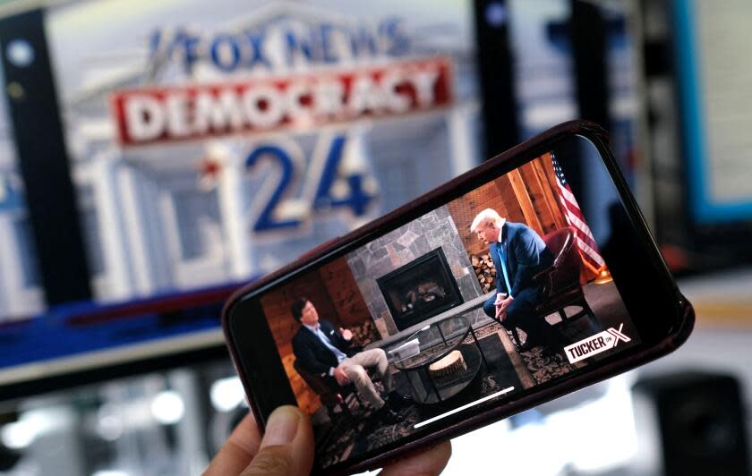 TOPSHOT - This illustration photo shows a preview of Tucker Carlson's interview of former US President Donald Trump scheduled to air on X (formerly Twitter) on the same night of the first Republican Presidential primary debate in Milwaukee, Wisconsin, on a smartphone ahead of the debate on August 23, 2023. (Photo by Chris DELMAS / AFP) (Photo by CHRIS DELMAS/AFP via Getty Images)