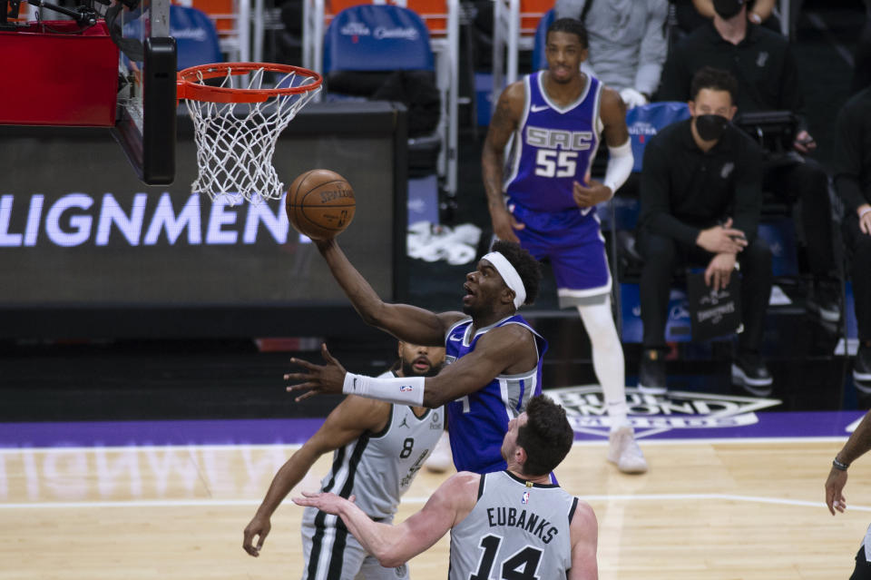 Sacramento Kings guard Terence Davis shoots as San Antonio Spurs guard Patty Mills (8) and forward Drew Eubanks (14) defend during the first quarter of an NBA basketball game in Sacramento, Calif., Friday, May 7, 2021. (AP Photo/Hector Amezcua)