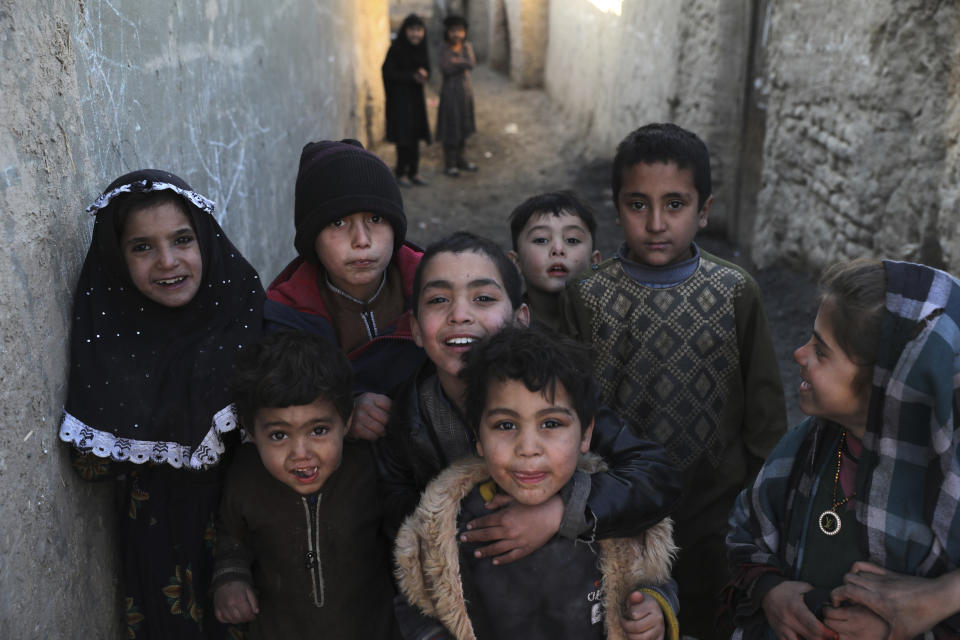 Internally displaced children pose for a photograph outside their temporary home in the city of Kabul, Afghanistan, Wednesday, Dec. 30, 2020. Save the Children has warned that more than 300,000 Afghan children face freezing winter conditions that could lead to illness, in the worst cases death, without proper winter clothing and heating. (AP Photo/Rahmat Gul)