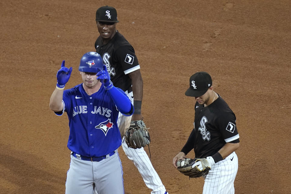 Toronto Blue Jays' Riley Adams celebrates his first hit in the majors, a double off Chicago White Sox starting pitcher Carlos Rodon, as White Sox's Tim Anderson, top, and Nick Madrigal stand nearby during the fifth inning of a baseball game Tuesday, June 8, 2021, in Chicago. (AP Photo/Charles Rex Arbogast)